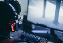 The Reasons for the Growing Popularity of Dota 2 person wearing orange and black headphones