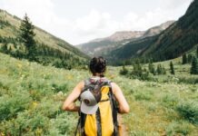Spending Time Outdoors: 6 Ailments to Watch Out For person carrying yellow and black backpack walking between green plants