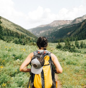 Spending Time Outdoors: 6 Ailments to Watch Out For person carrying yellow and black backpack walking between green plants