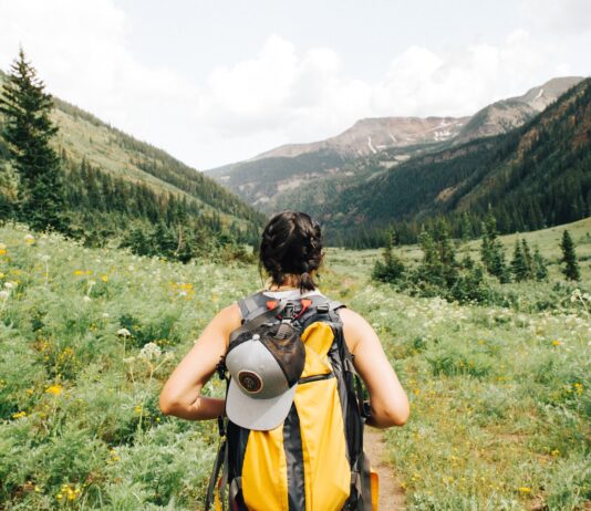 Spending Time Outdoors: 6 Ailments to Watch Out For person carrying yellow and black backpack walking between green plants