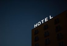 Book a hotel room for a day? It is now possible! low-angle photo of Hotel lighted signage on top of brown building during nighttime