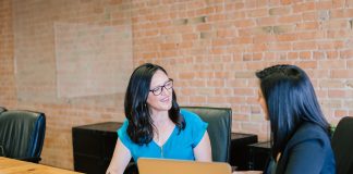 Why is a Parent Company One of the Key Pathways to Business Success in the 2020s? woman in teal t-shirt sitting beside woman in suit jacket