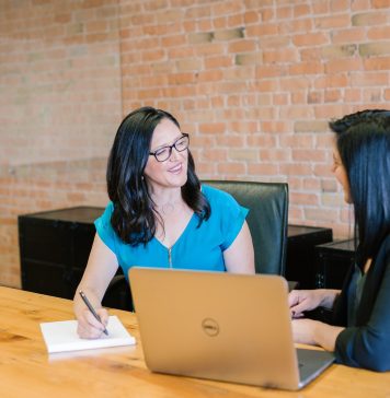 Why is a Parent Company One of the Key Pathways to Business Success in the 2020s? woman in teal t-shirt sitting beside woman in suit jacket