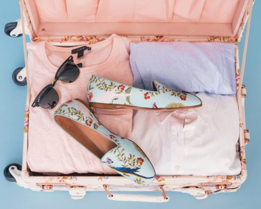 5 Summer Essentials You Need in Your Wardrobe clothing items and pair of shoes in luggage