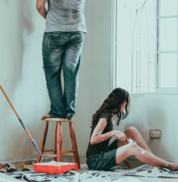 Living on ROI Street: 8 Elements That Can Increase the Resale Value of Your Custom Home woman in gray tank top and blue denim jeans sitting on bed