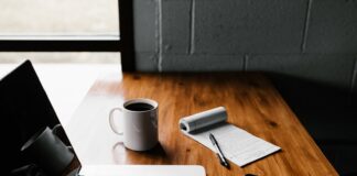 Managing Your Finances in Your Business MacBook Pro, white ceramic mug,and black smartphone on table