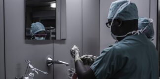 4 Tips for Digging Out of Medical Debt man wearing surgical suit near mirror