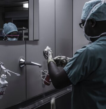 4 Tips for Digging Out of Medical Debt man wearing surgical suit near mirror