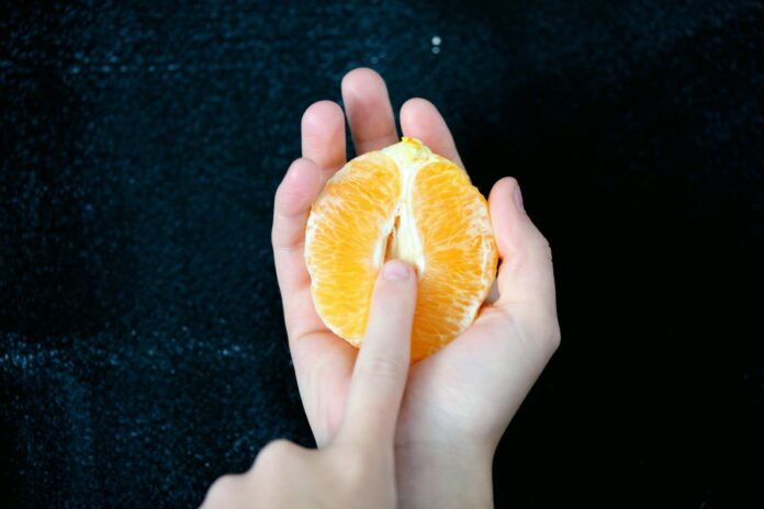 Photo by Alexander Grey person holding sliced orange fruit