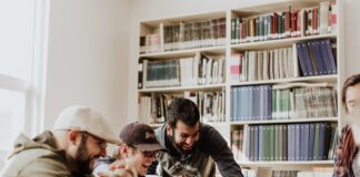3 Ways To Improve Your Business Pitch To Investors three men laughing while looking in the laptop inside room