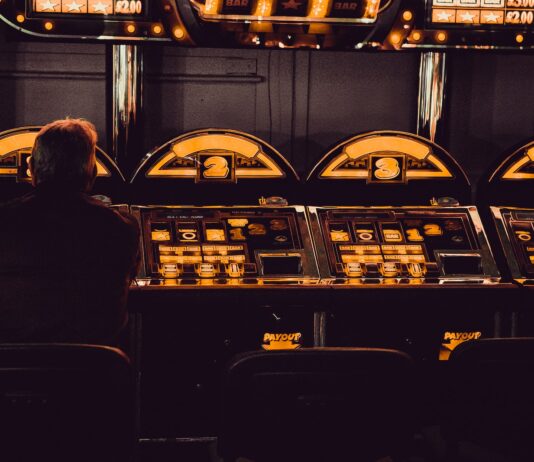 The Development Of Internet Gambling man playing arcade machine