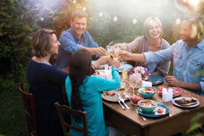 Group,Of,Friends,In,Their,Forties,Gathered,Around,A,Table