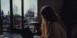 Exploring the benefits of remote notarization New York woman in gray sweater using laptop computer