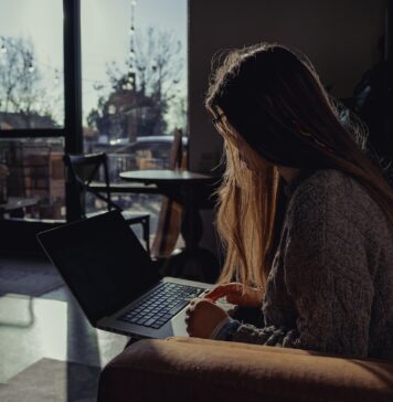 Exploring the benefits of remote notarization New York woman in gray sweater using laptop computer