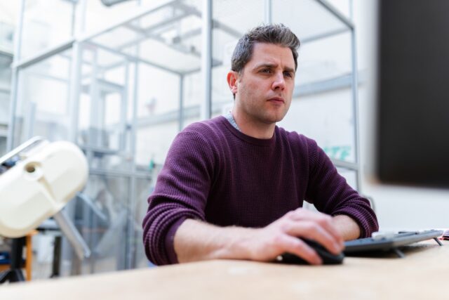 Photo by ThisisEngineering RAEng man in purple sweater sitting at the table