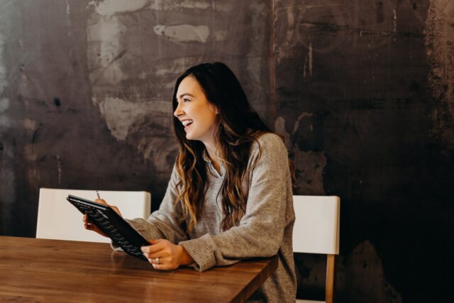 Photo by Brooke Cagle woman sitting around table holding tablet