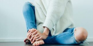 5 Tips for Dealing with Plantar Fasciitis person wearing distressed blue denim jeans inside room