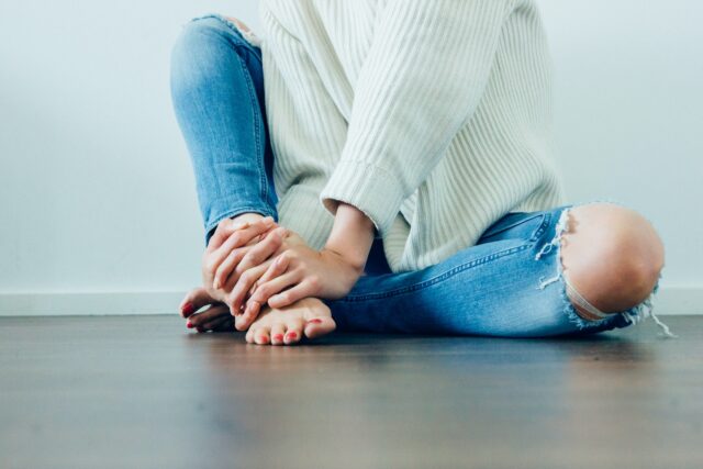 Photo by Imani Bahati person wearing distressed blue denim jeans inside room