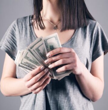Top 10 Apps Like Big Cash to Play and Earn Money From Home woman in gray shirt holding fan of us dollar bills