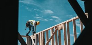 Reasons to Hire Construction Injury Attorneys in Chicago, Illinois man in yellow shirt and blue denim jeans jumping on brown wooden railings under blue and