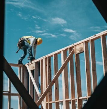 Reasons to Hire Construction Injury Attorneys in Chicago, Illinois man in yellow shirt and blue denim jeans jumping on brown wooden railings under blue and