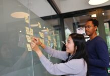 Understanding the Different Types of Roles in Product Management woman in gray sweater holding gold iphone 6