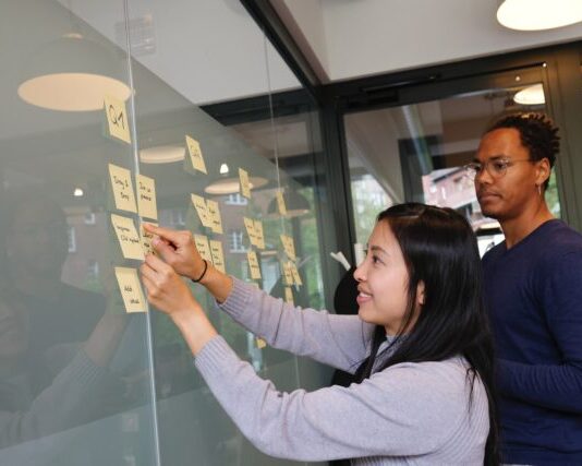 Understanding the Different Types of Roles in Product Management woman in gray sweater holding gold iphone 6