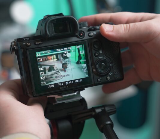 How to Create the Perfect Product Video in 2023 a person holding a camera up to take a picture