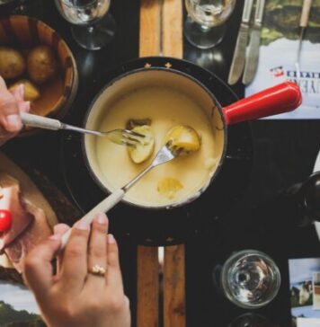 5 Ideas for an Unusual House Party two person holding fork dipping food on sauce