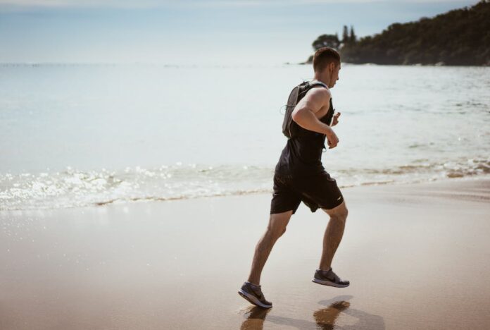 free-man-wearing-black-tank-top-and-running-on-sea Free Man Wearing Black Tank Top and Running on Seashore Stock Photo