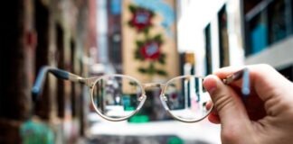 Pros and Cons of Getting Same-Day Prescription Glasses person holding eyeglasses