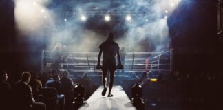 Knockout Wins: Explore the World of Online Boxing Betting at Leon India man standing and walking going on boxing ring surrounded with people
