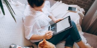 The Future of Remote Work is in Luxurious Destinations and Work-Life Balance woman in white long sleeve shirt and blue denim shorts sitting on bed using tablet computer