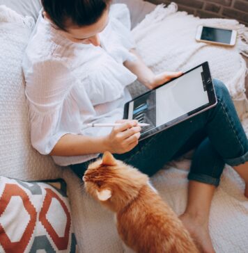 The Future of Remote Work is in Luxurious Destinations and Work-Life Balance woman in white long sleeve shirt and blue denim shorts sitting on bed using tablet computer