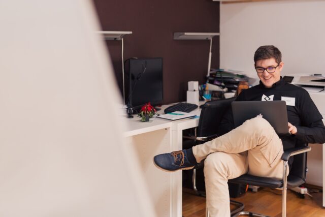 Photo by Csaba Balazs man smiling while sitting and using MacBook