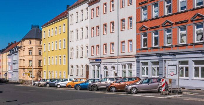 Photo by Sangga Rima Roman Selia assorted-color cars parked beside apartments