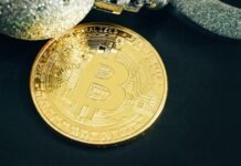 Unveiling the Perks of Bitcoin Casino Games a gold bit coin sitting on top of a black table