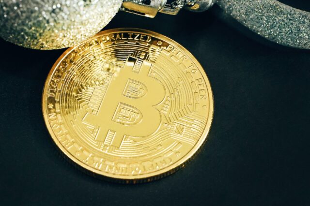 Photo by Traxer a gold bit coin sitting on top of a black table