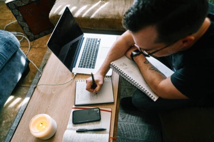 Photo by ConvertKit man in black t-shirt writing on white paper