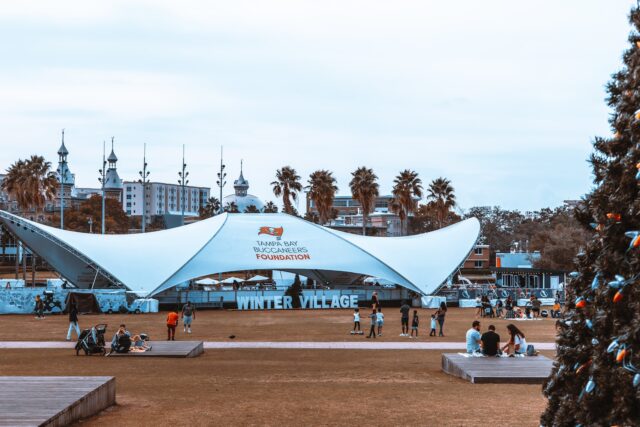 Photo by Densky Simon people sitting on bench under blue and white canopy tent during daytime