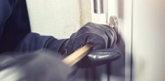 Things to Consider Before Buying a Home Burglar Alarm System Free Person Opening a Door with a Bar Stock Photo