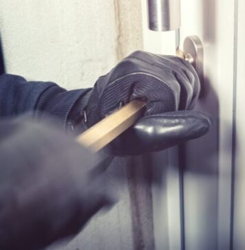 Things to Consider Before Buying a Home Burglar Alarm System Free Person Opening a Door with a Bar Stock Photo