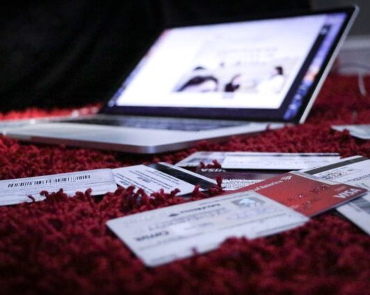 5 Ways Social Media Can Make You Go into Debt white printer paper on red textile