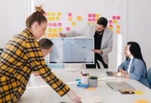 Unmasking the Influence of AI in Knowledge Management A team in an office discussing AI knowledge management during a meeting