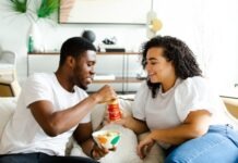 What Are the Differences Between Free and Paid Features on Muslim Dating Sites: Navigating User Experience man in white crew neck t-shirt and blue denim jeans sitting on white sofa chair