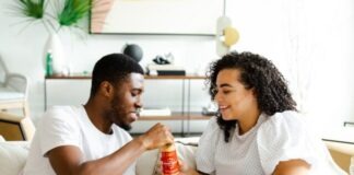 What Are the Differences Between Free and Paid Features on Muslim Dating Sites: Navigating User Experience man in white crew neck t-shirt and blue denim jeans sitting on white sofa chair