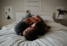 The Power of Intimacy and Sexual Health: Connecting on Physical and Emotional Levels A man and woman cuddling together in bed.