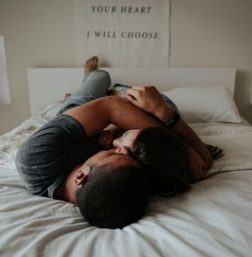 The Power of Intimacy and Sexual Health: Connecting on Physical and Emotional Levels A man and woman cuddling together in bed.