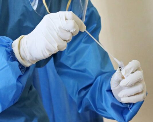 Oligonucleotides 101: What It Is, How They’re Made, and Applications person in blue jacket holding white textile