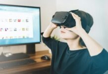 Technology Shaping the Future of Gaming woman using black VR headset beside computer